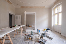 A room under renovation with tools and materials scattered across the floor