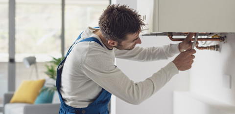 A tradesperson is working on a broken boiler.